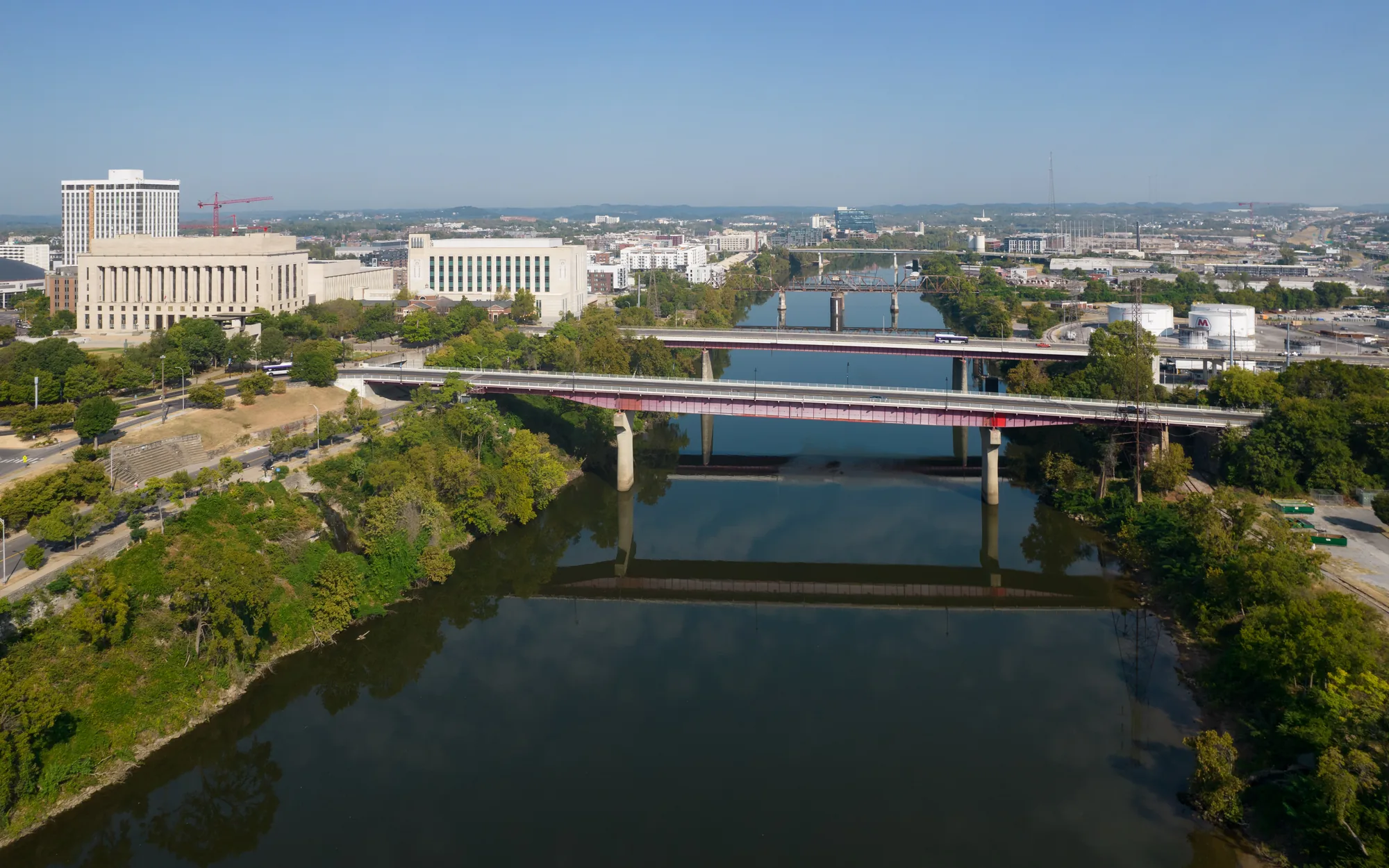 Aerial view along the Cumberland River in Nashville, with four bridges lined up one behind another and the Davidson County Courthouse on the left bank