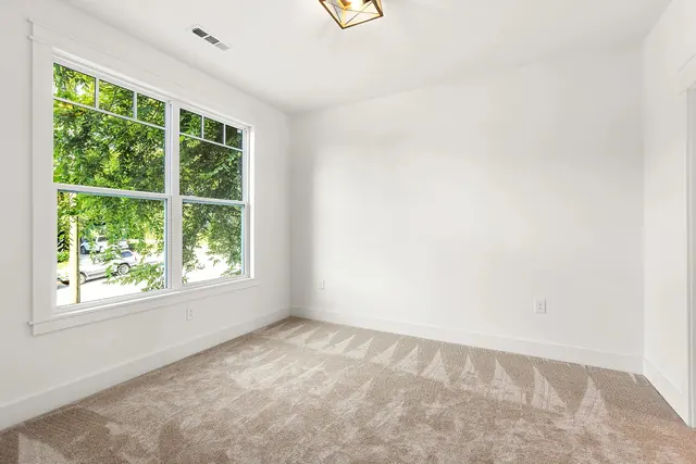 Carpeted bedroom with window at 1108 Lenore St, Nashville, TN 37206